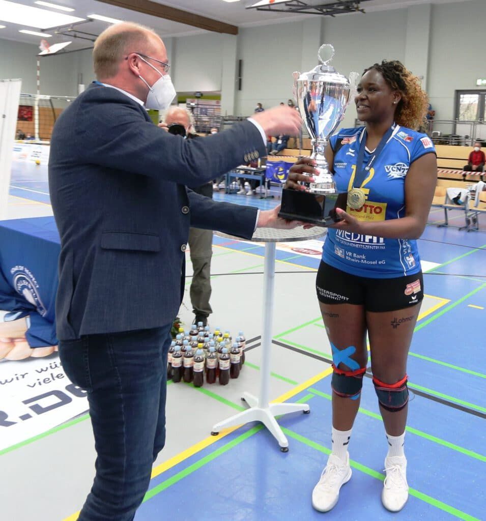 Der Meisterpokal, den Mannschaftsführerin Sarah Kamarah hier aus der Hand von VBL-Vertreter Heino Konjer erhält, steht inzwischen in der Vitrine. Für die Mannschaft beginnt am Samstag in Bayern der Epilog der Meistersaison (Foto Eckhard Schwabe)